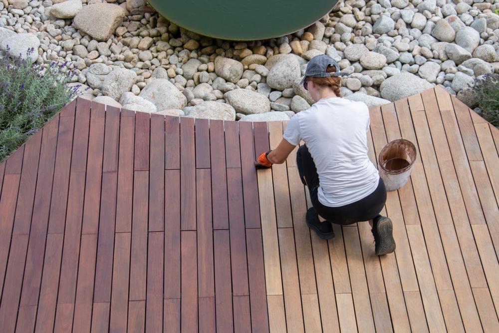 woman staining her wood deck in middle tennessee supplied by deck supply of nashville